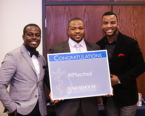A group of men holding a sign that says 'I matched'