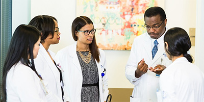 a group of physician assistants listening to a doctor